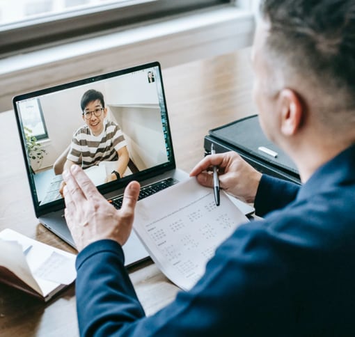 A man in front of a laptop during a video meeting